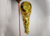 Λαμπρό καλυμμένο χρυσός φλυτζάνι τροπαίων συνήθειας με το άγαλμα που κρατά το σχέδιο σφαιρών